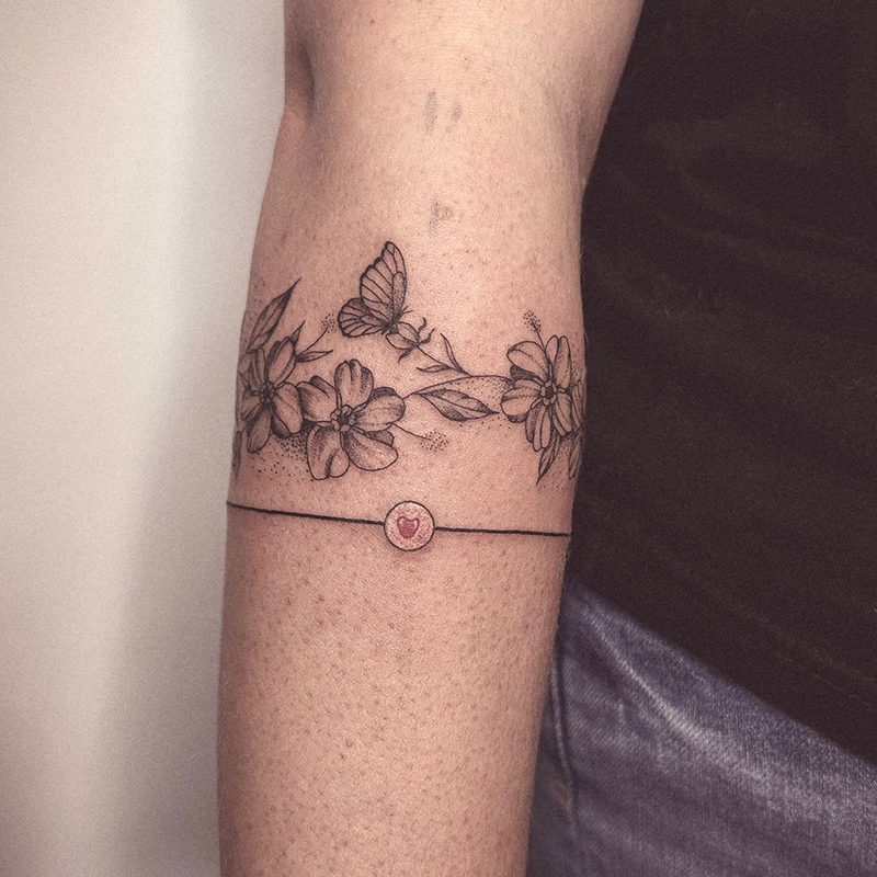 Foto van fijne lijn-tattoo met een klein hartje en bloemen.